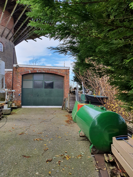 De Hoop, Wolphaartsdijk, Pieter Zuijkerbuijk (9-11-2019)De ingang van de schuur/werkplaats aan de voorzijde, rechts zie je de ontkoppelde dieseltank | Database Nederlandse molens
