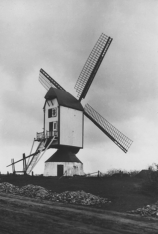 (standerdmolen), , Historische foto van de molen met een nog open gebied rondom. De weg wordt zo te zien verhard.  Foto n.n. (ca. 1930), ingezonden door Rob Pols. | Database Nederlandse molens