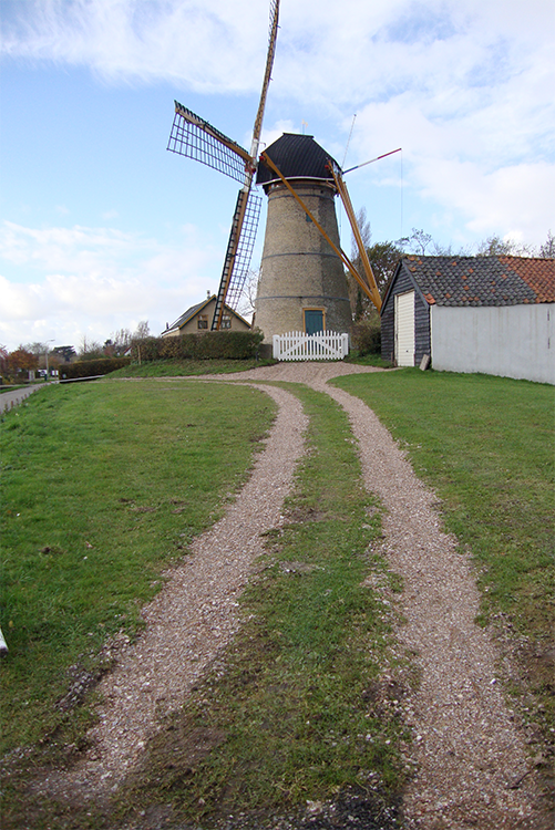 (stenen grondzeiler), Oostvoorne, Jorrit de Laat (16-7-2016). De molen met het pas gereconstrueerde pad naar de molen en de gekapte bomen op het noorden. ook het groene hek is verwijderd. | Database Nederlandse molens